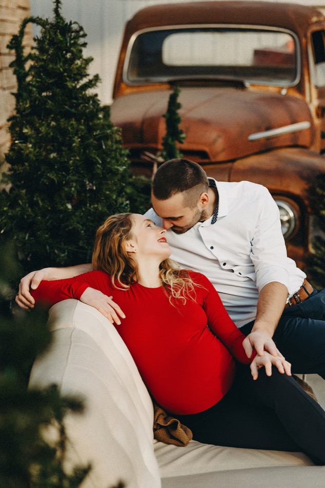 Couple sharing a tender moment in a festive maternity session