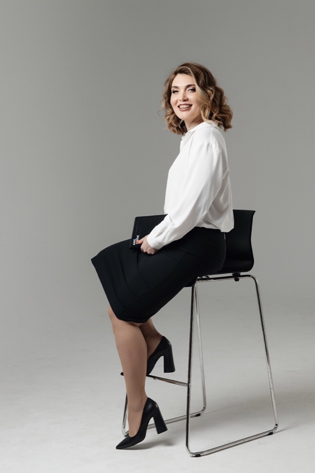 Woman in a white blouse seated in a studio
