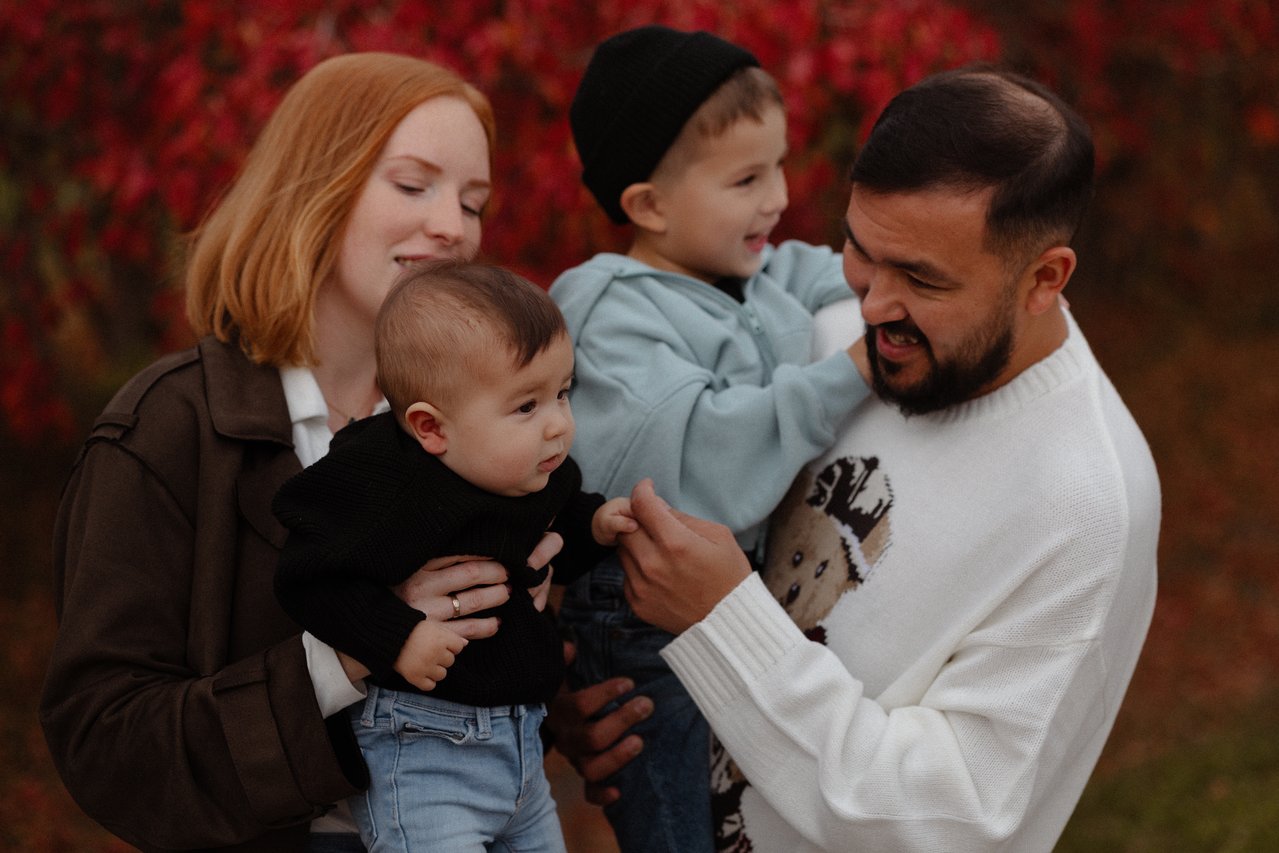 Alina and Nurali holding their children close during an autumn family session at Minnewasta in Morden.