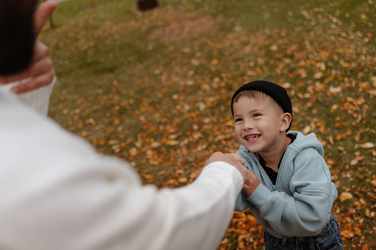 David smiling up towards his father during their outdoor family session.