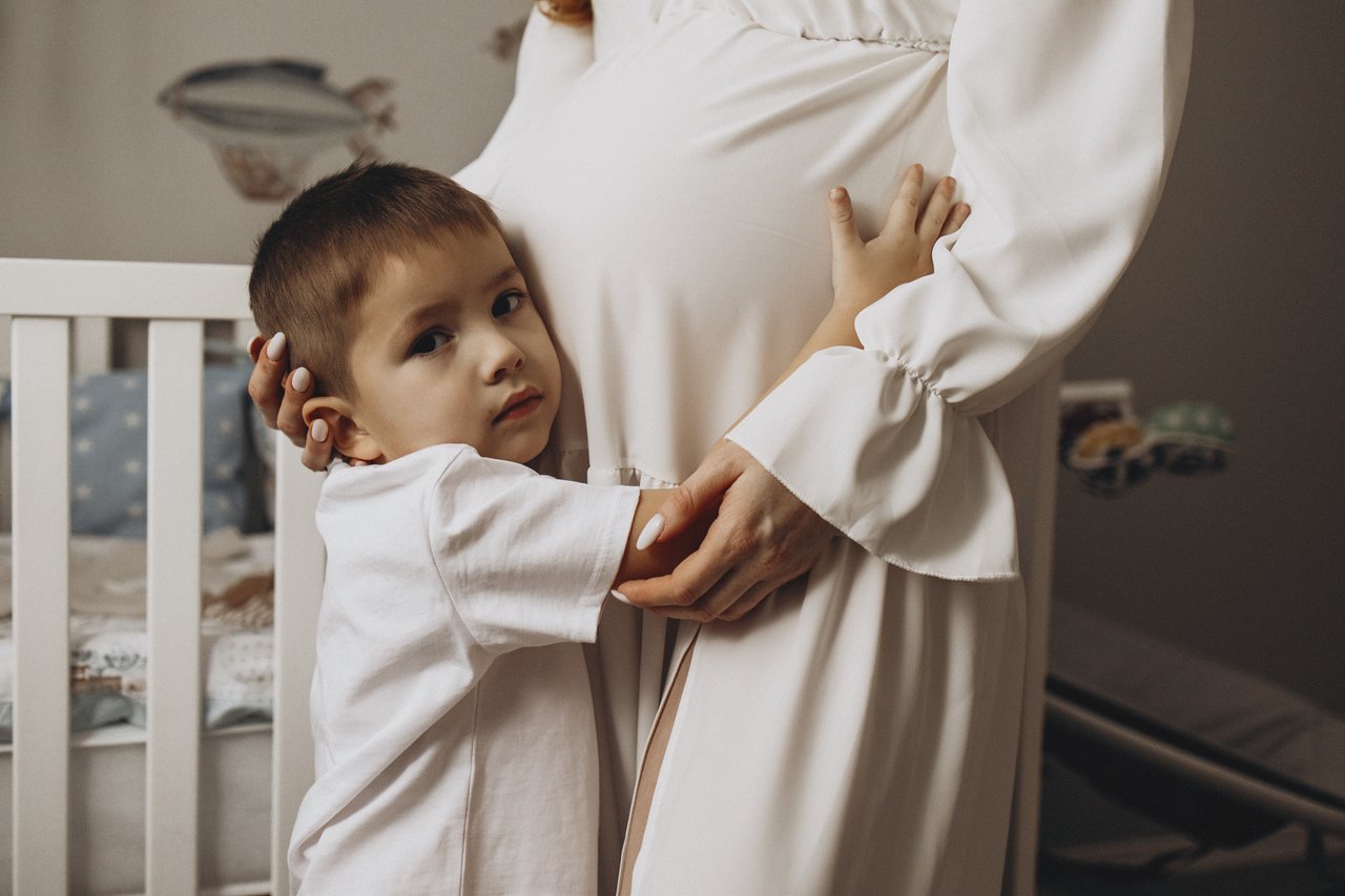 David embracing Alina’s bump while she gently holds him close.
