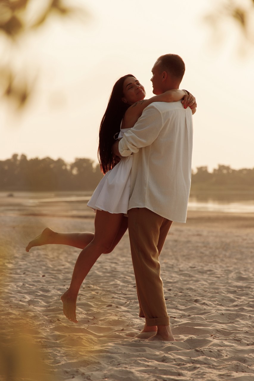 Parents embracing close to the water in warm evening light
