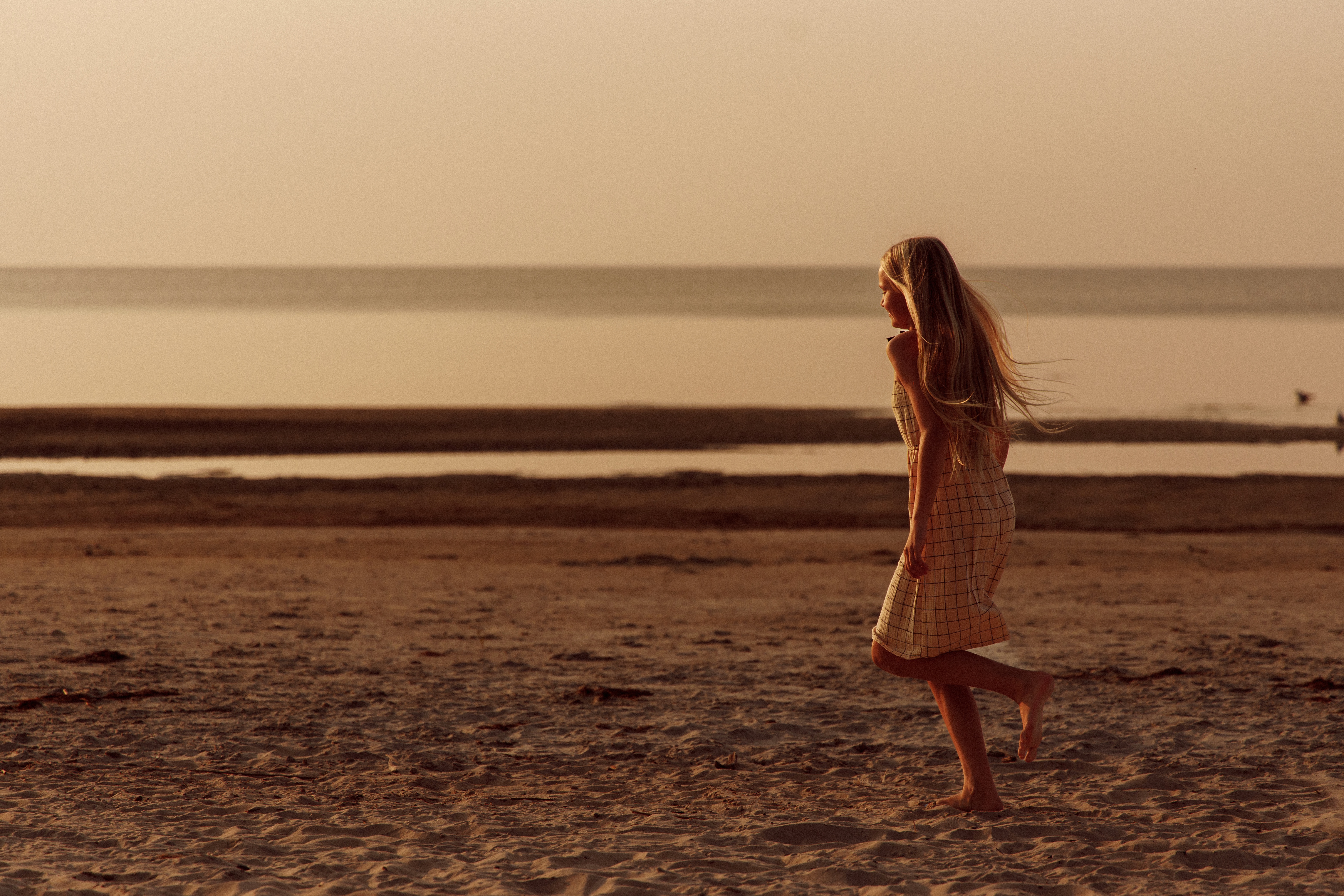 Woman walking beside the water in warm evening light