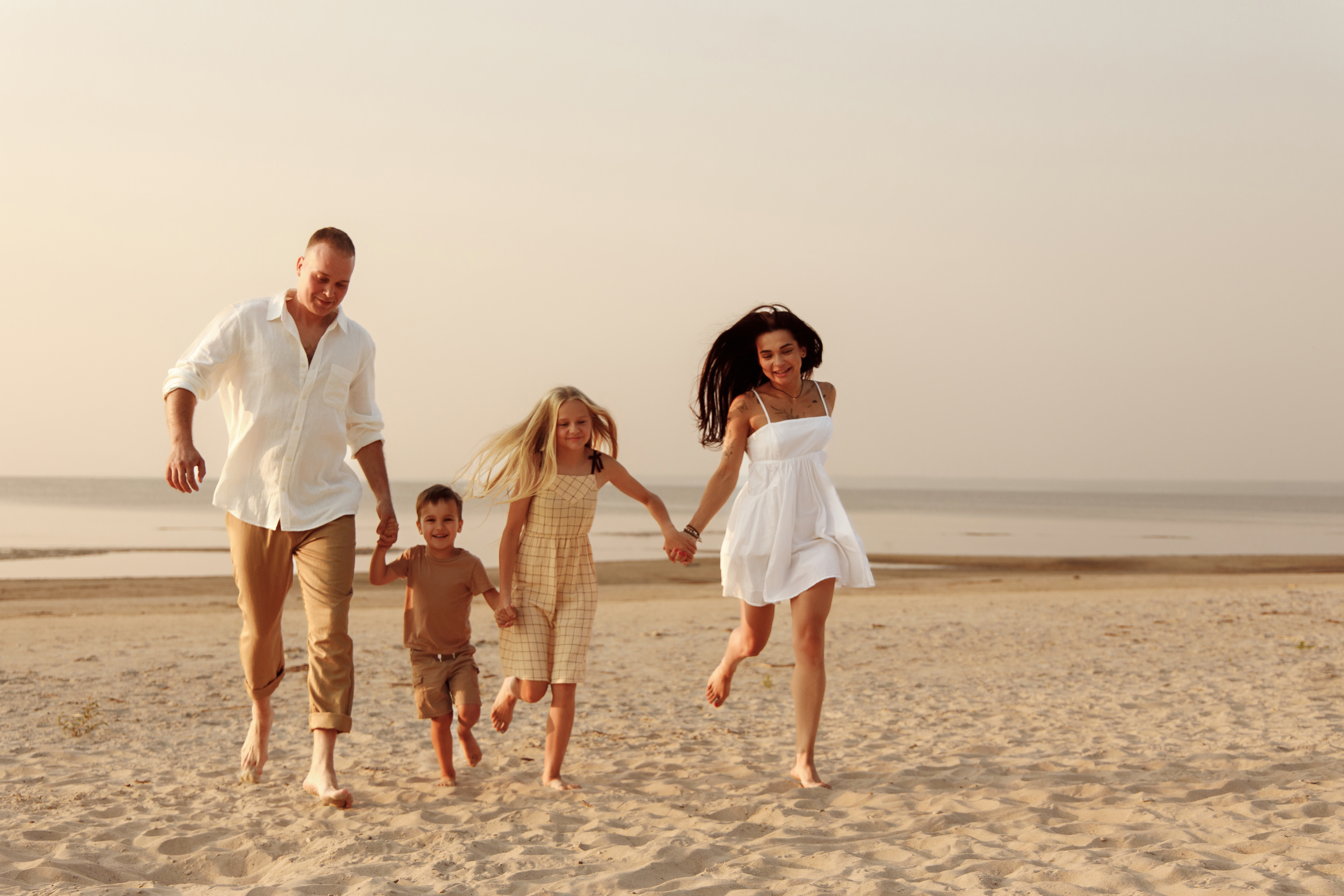 Family walking together along the shoreline at sunset